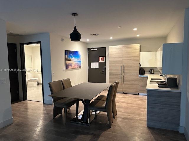 dining space with sink and wood-type flooring