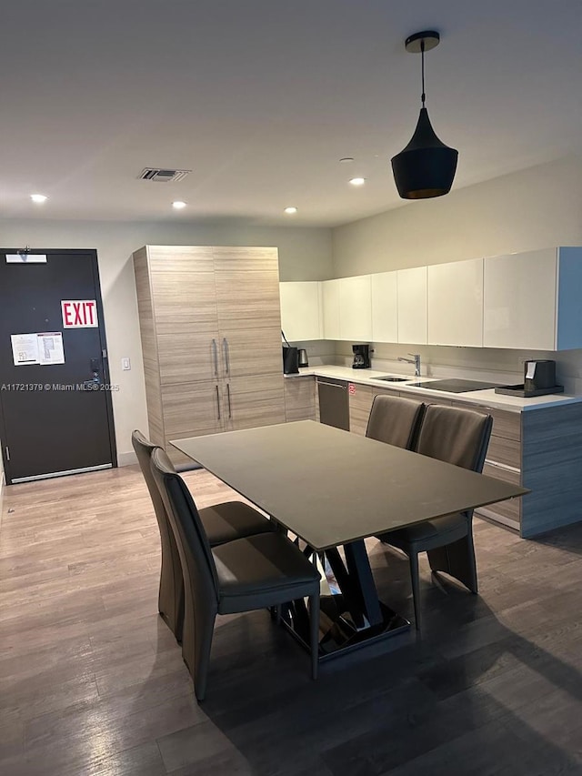 dining space with light wood-type flooring and sink