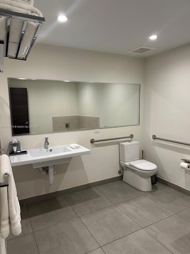 bathroom with toilet, tile patterned floors, and sink