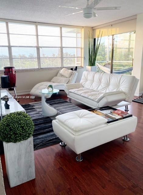 living room with ceiling fan and dark wood-type flooring