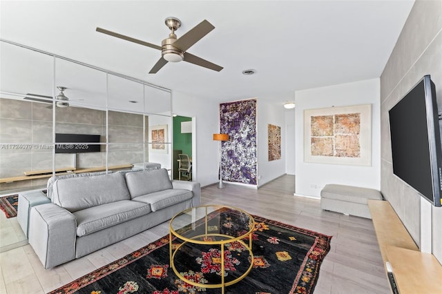 living room with ceiling fan and light hardwood / wood-style flooring