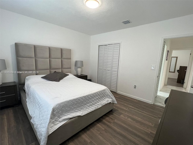 bedroom featuring a closet, a textured ceiling, and dark wood-type flooring