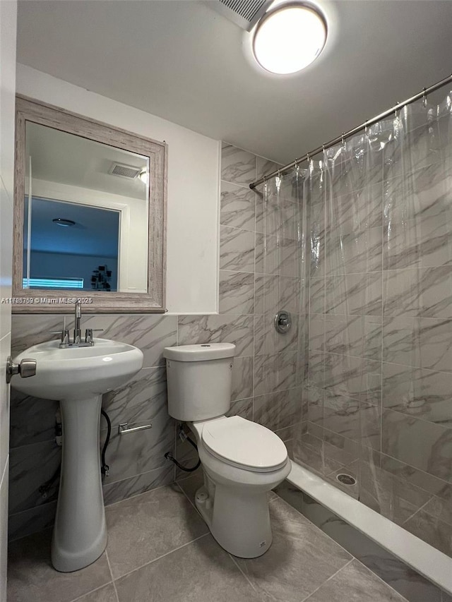 bathroom with tile walls, a shower with shower curtain, and toilet