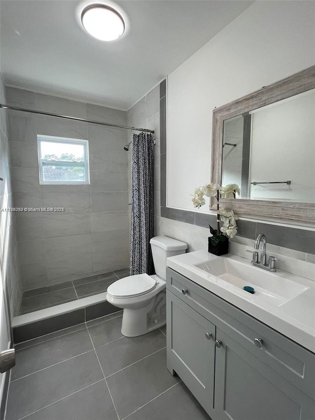 bathroom featuring toilet, tile patterned floors, walk in shower, and vanity