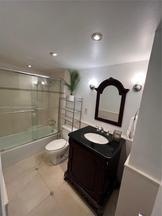 full bathroom with enclosed tub / shower combo, tile patterned flooring, vanity, and toilet