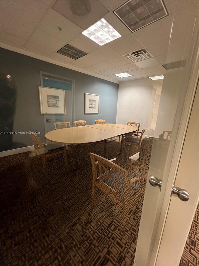 dining area with ornamental molding and a paneled ceiling