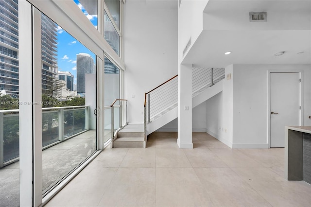 kitchen featuring light tile patterned flooring, rail lighting, sink, kitchen peninsula, and a raised ceiling