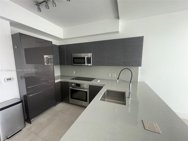 kitchen with appliances with stainless steel finishes, sink, and light tile patterned floors