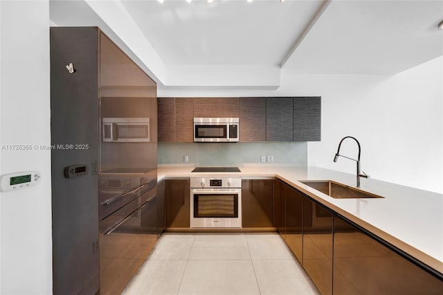 kitchen with light tile patterned flooring, appliances with stainless steel finishes, and sink