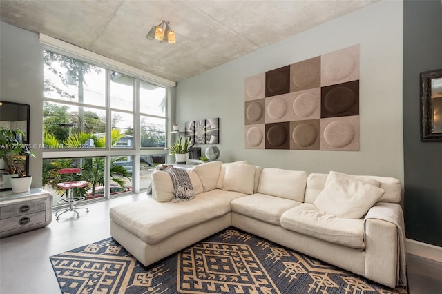 living room with a wall of windows and concrete floors