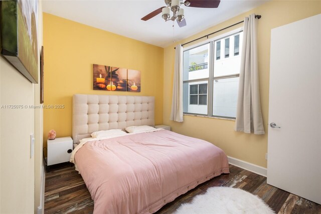 bedroom featuring dark hardwood / wood-style flooring, access to exterior, and ceiling fan