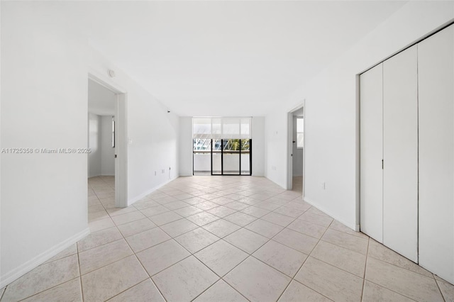 tiled empty room with a wall of windows