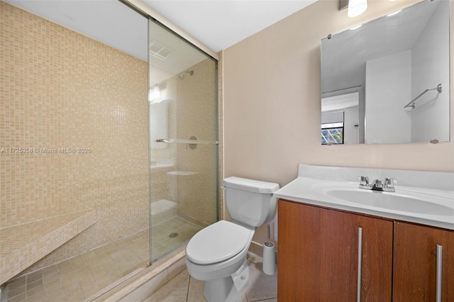 bathroom with toilet, a shower with shower door, tile patterned floors, and vanity