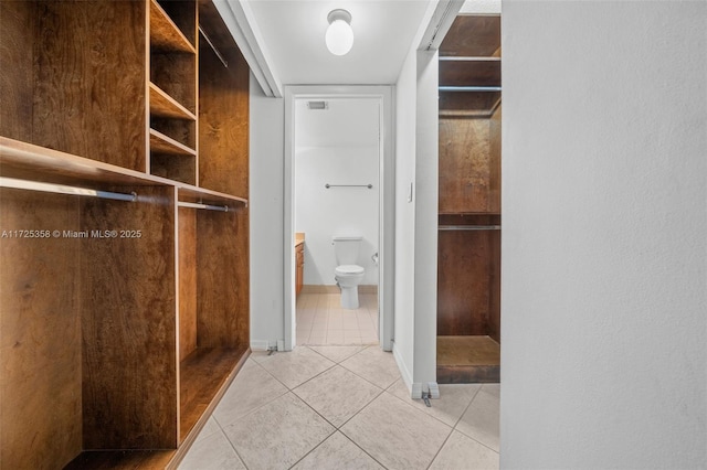 walk in closet with light tile patterned floors