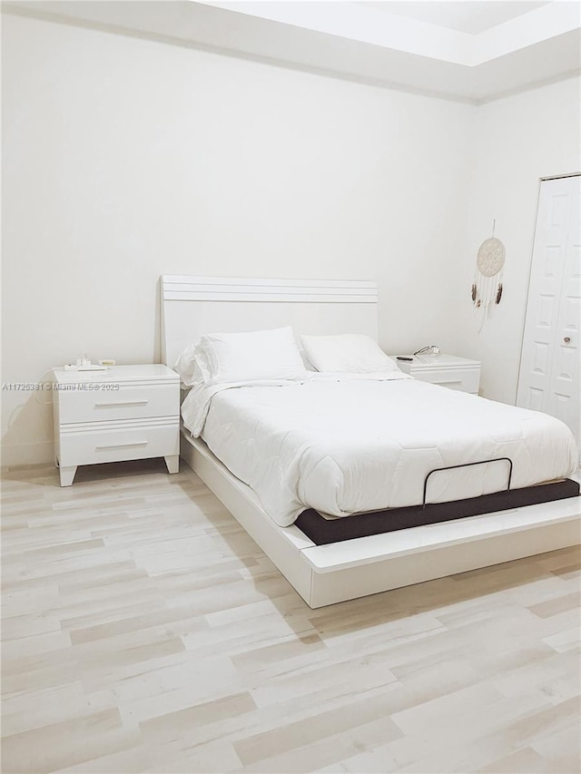 unfurnished bedroom featuring a closet and light hardwood / wood-style flooring