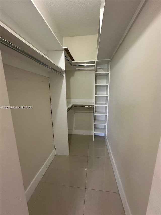 walk in closet featuring tile patterned flooring