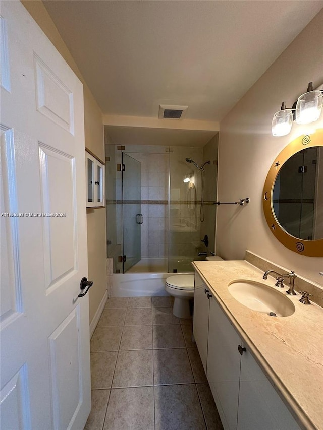 full bathroom with toilet, tile patterned flooring, vanity, and combined bath / shower with glass door