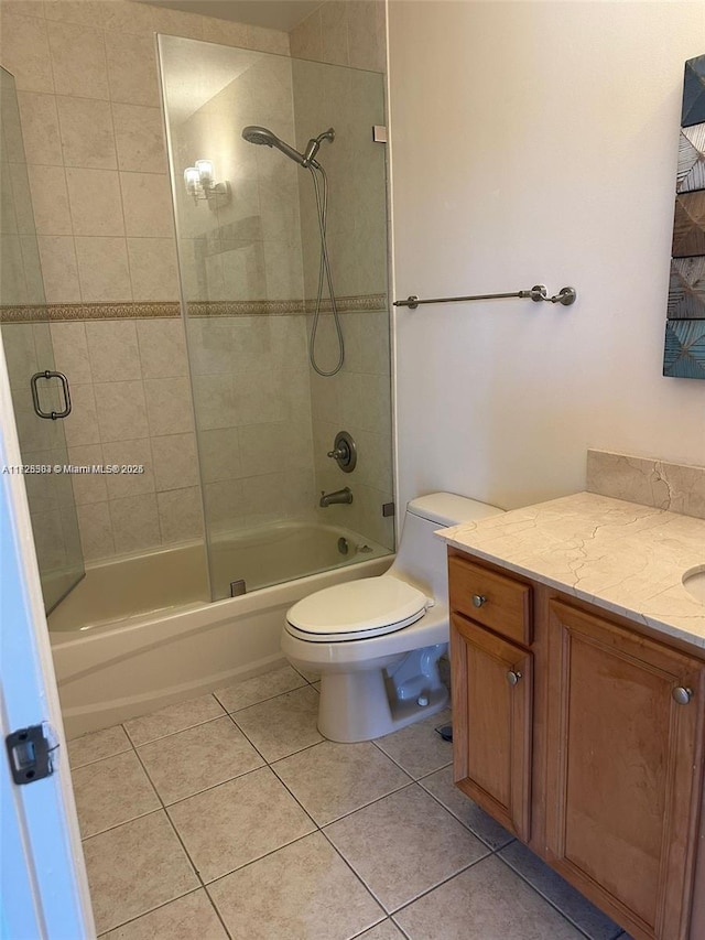 full bathroom featuring tile patterned flooring, bath / shower combo with glass door, vanity, and toilet