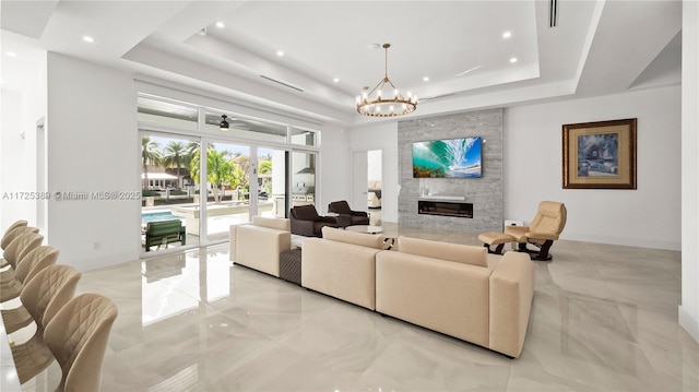 living room featuring a raised ceiling, french doors, and a fireplace