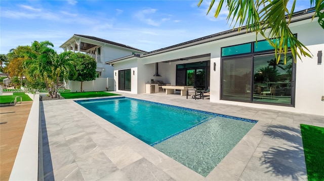 rear view of house featuring ceiling fan, a patio area, a balcony, and area for grilling