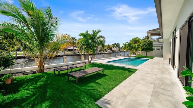 view of swimming pool with a patio area, a yard, and a water view