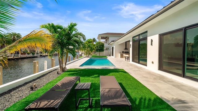 view of pool with a water view, a lawn, and a patio area