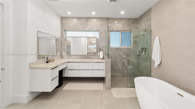 bathroom featuring tile walls, tile patterned floors, vanity, and separate shower and tub