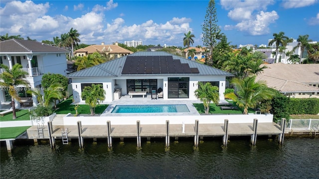 back of house with a water view, an outdoor living space, and a patio