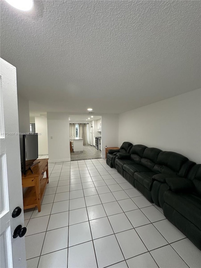 living room with a textured ceiling and light tile patterned floors