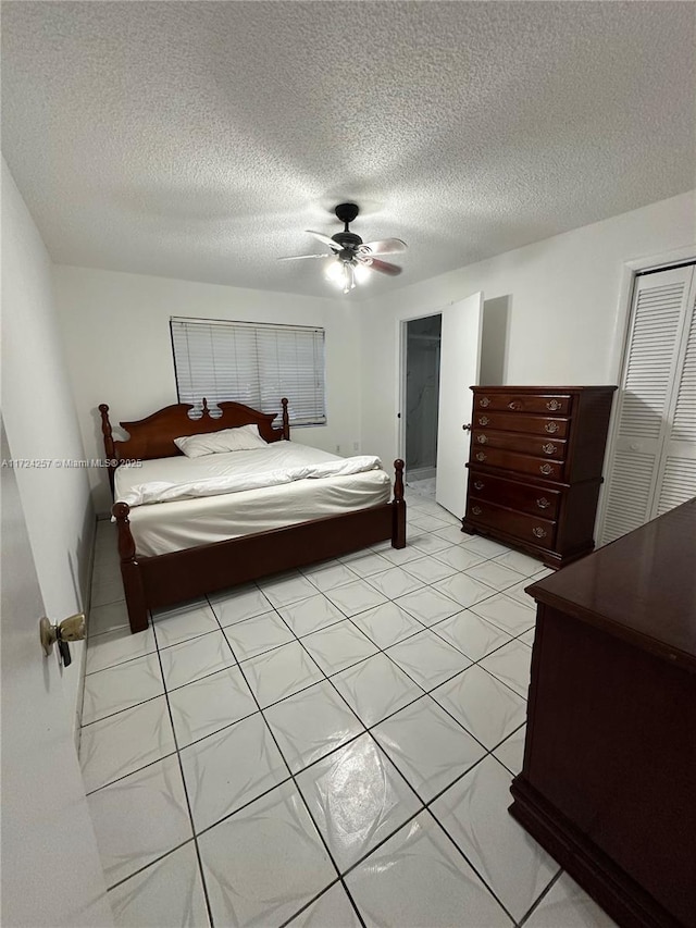 bedroom with a textured ceiling, ceiling fan, and a closet