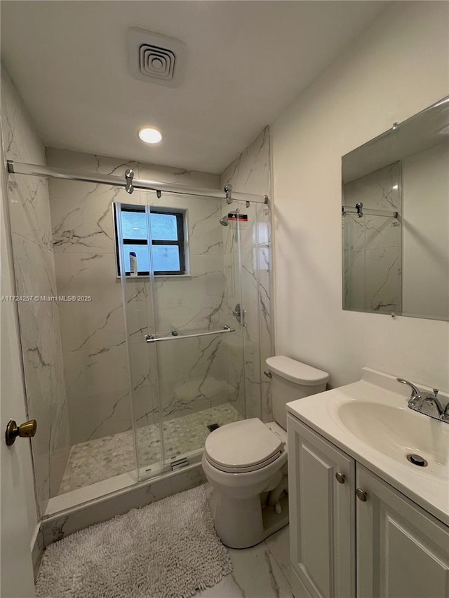 bathroom with walk in shower, vanity, and toilet