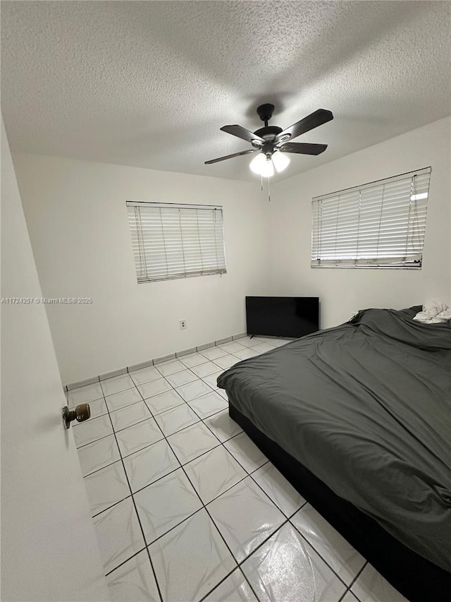 bedroom featuring ceiling fan and a textured ceiling