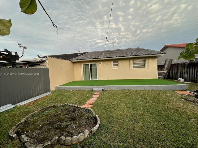 rear view of property with a lawn