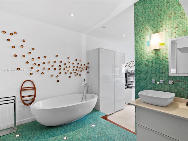 bathroom featuring tile walls, a tub, tile patterned flooring, and vanity