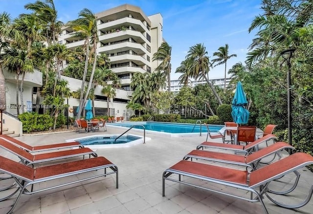 view of pool featuring a community hot tub and a patio area