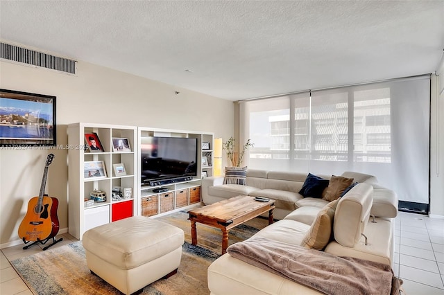 tiled living room featuring a textured ceiling