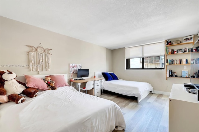 bedroom featuring a textured ceiling and light wood-type flooring