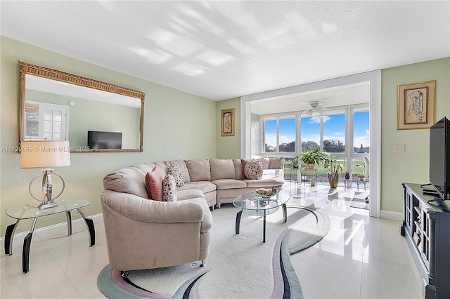 living room featuring a textured ceiling, ceiling fan, and light tile patterned floors