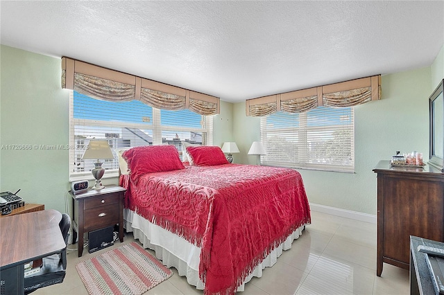 tiled bedroom featuring a textured ceiling