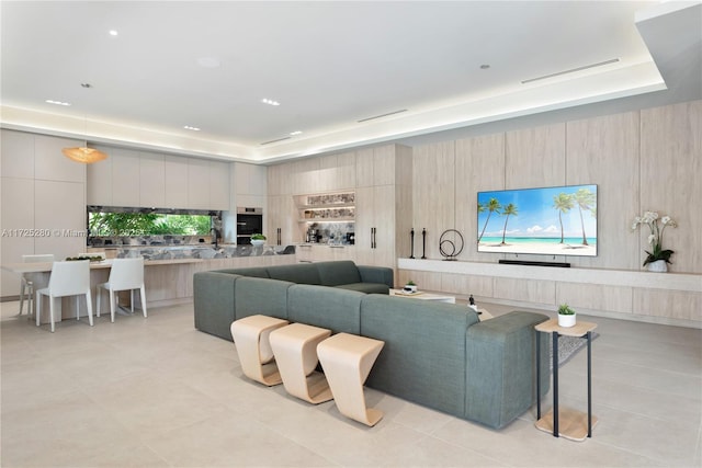 tiled living room featuring a tray ceiling