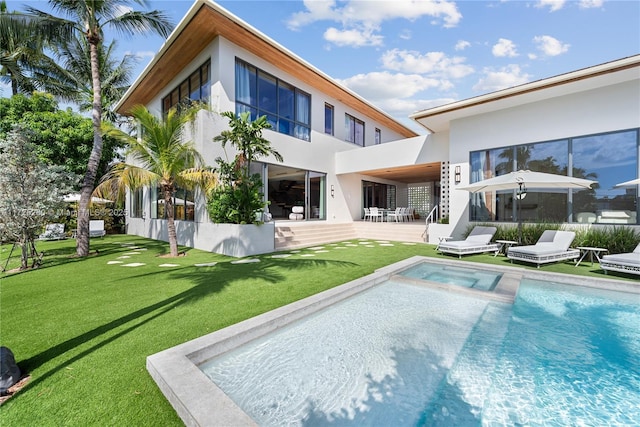 rear view of property featuring a patio area, a lawn, and a fenced in pool