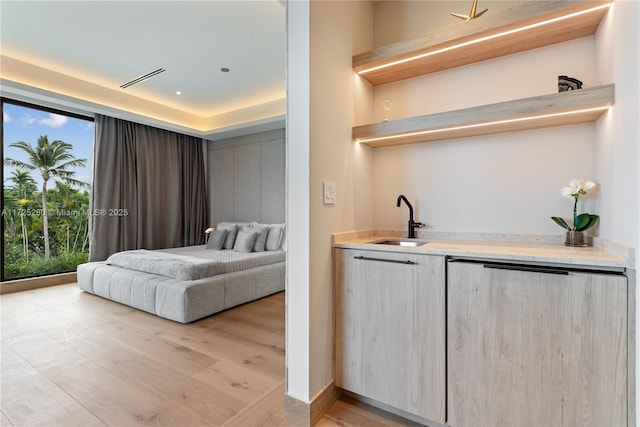 bedroom with sink and light hardwood / wood-style flooring