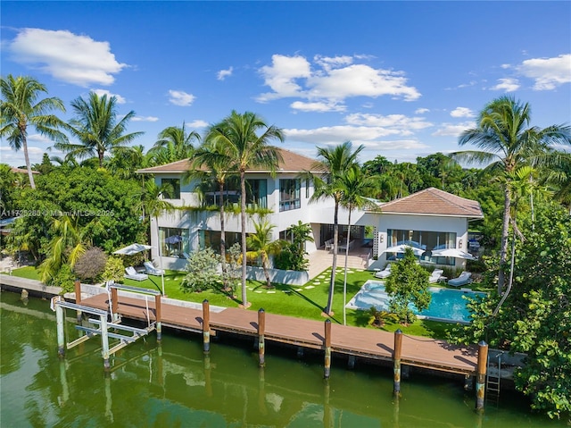 back of property with a patio area, a balcony, a pool, and a water view