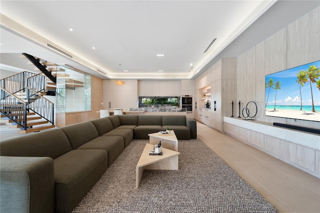 living room featuring a raised ceiling and light tile patterned flooring