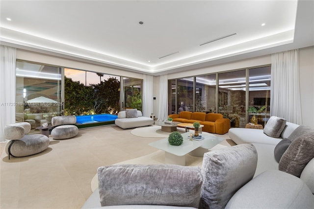 living room featuring tile patterned floors and a tray ceiling