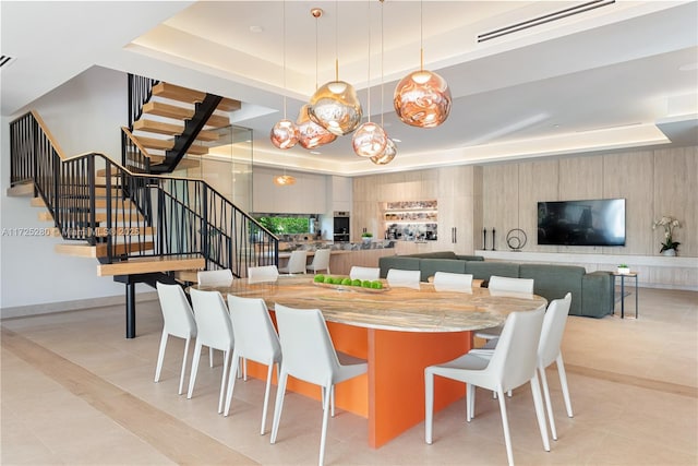 dining room with light tile patterned flooring and a raised ceiling