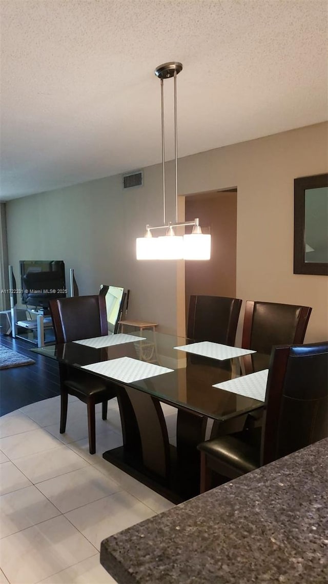 tiled dining space featuring a textured ceiling