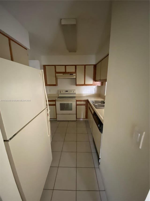 kitchen featuring light countertops, light tile patterned flooring, a sink, white appliances, and under cabinet range hood