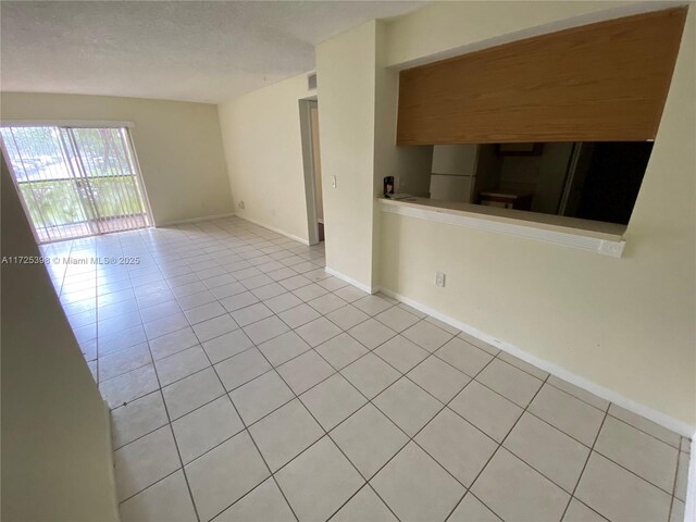 spare room featuring light tile patterned flooring and a textured ceiling