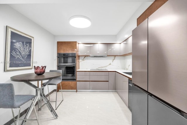 kitchen with double oven, decorative backsplash, and stainless steel refrigerator